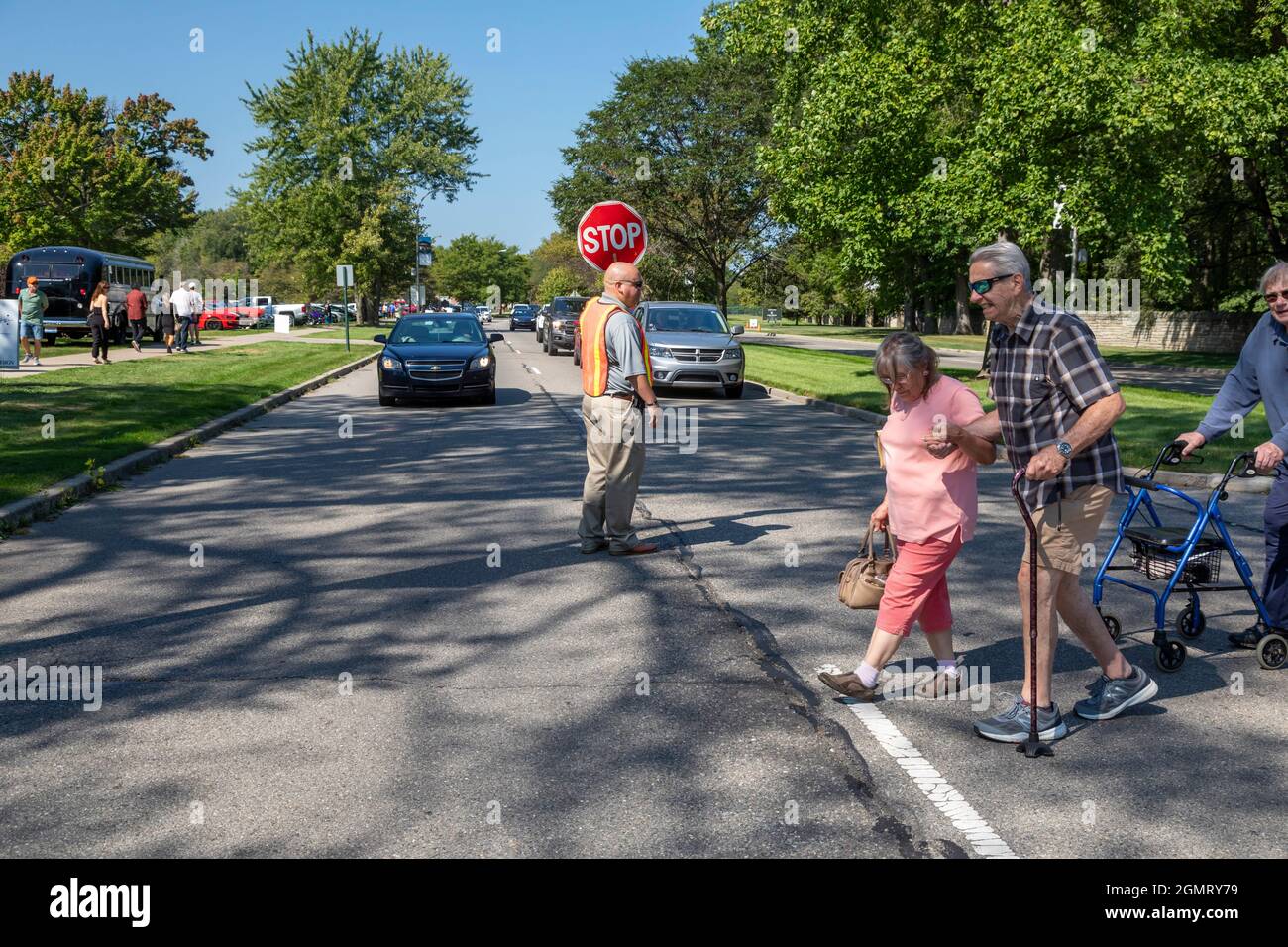 Grosse Pointe Shores, Michigan - A crossing guard stops traffic for pedestrians attending the Eyes on Design auto show at the Edsel & Eleanor Ford Hou Stock Photo