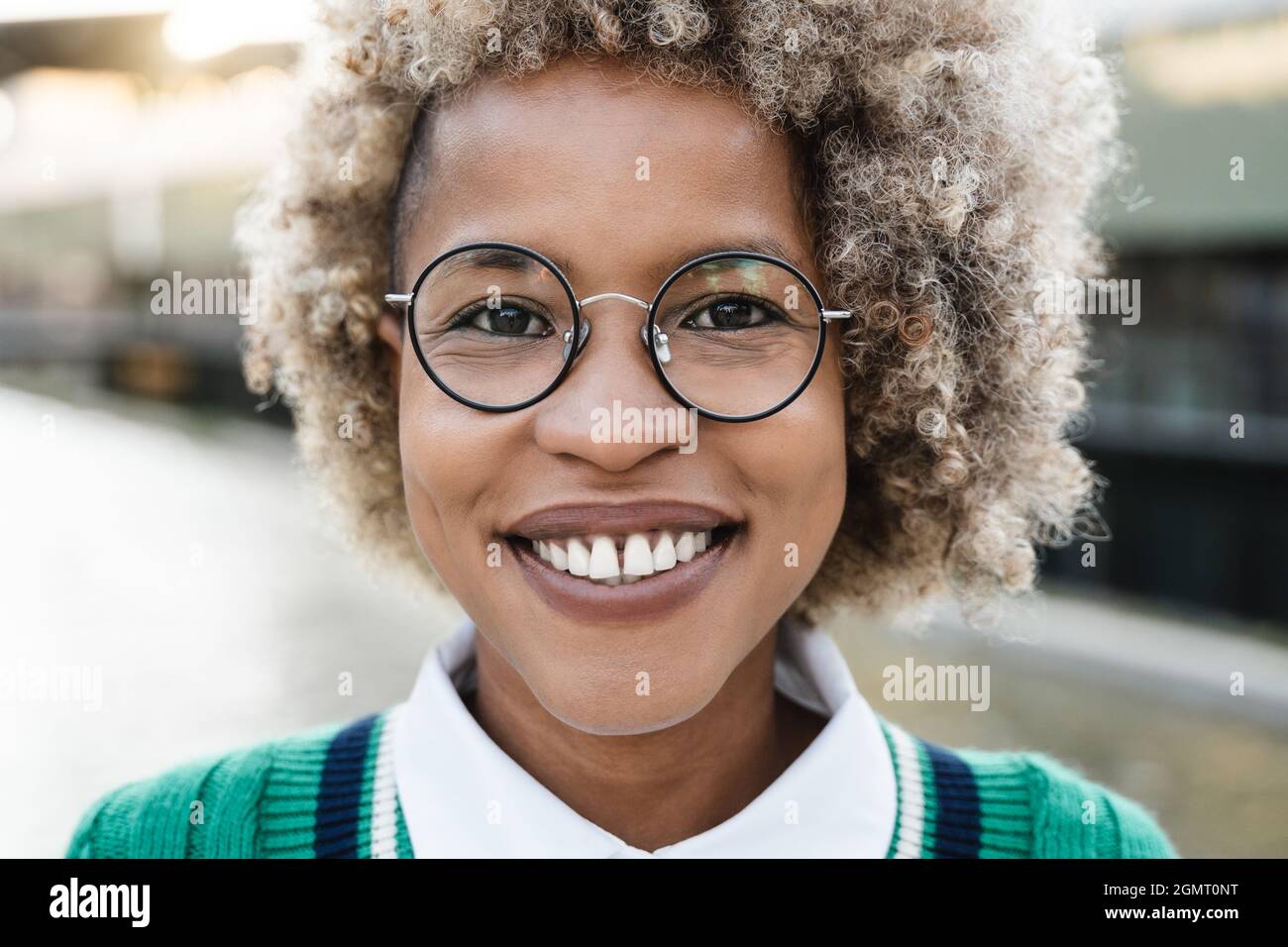 Portrait of young african girl smiling on camera outdoor in the city ...