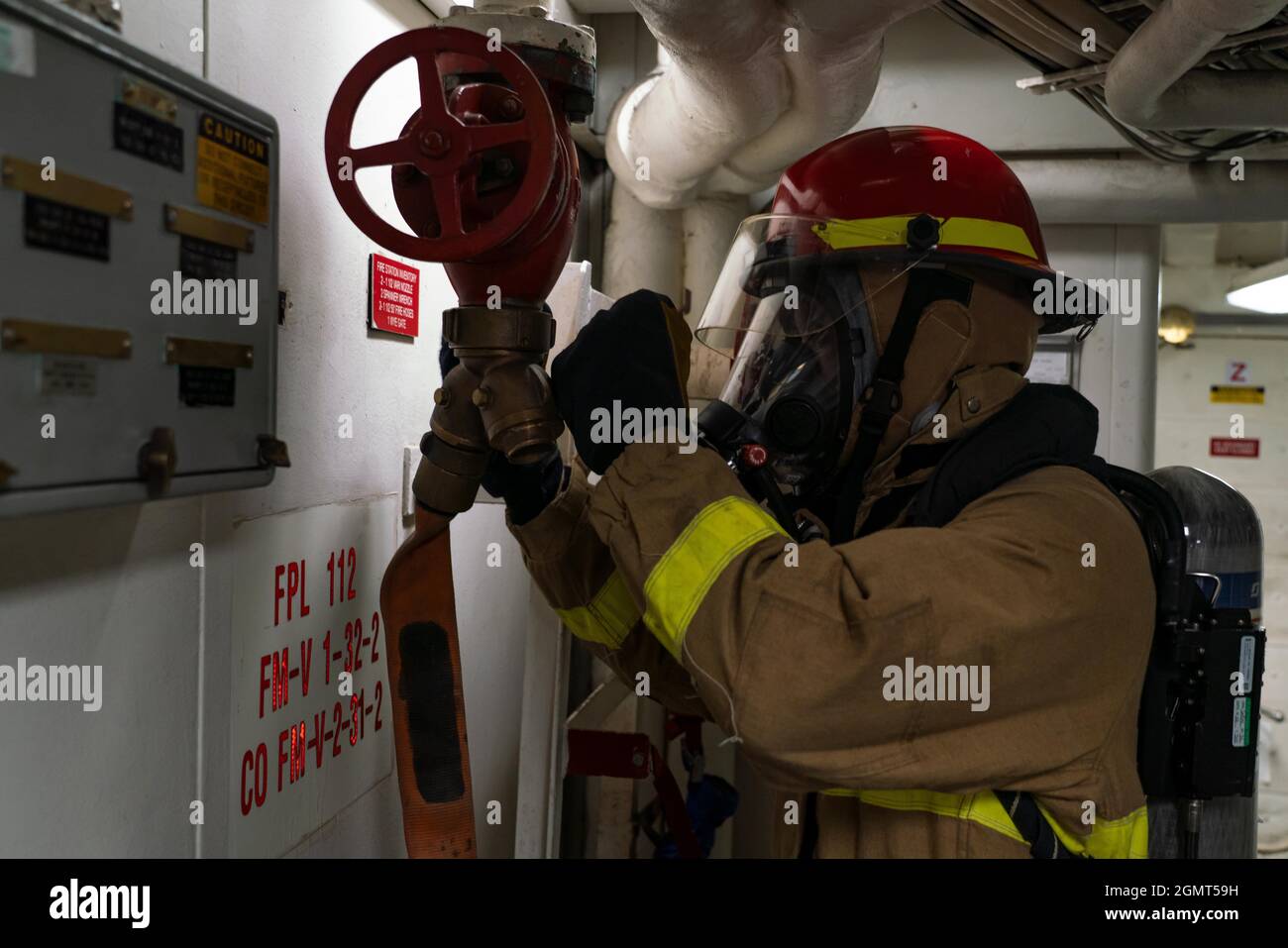 PACIFIC OCEAN (September 9, 2021) Fireman Andre Green, from Atlanta, checks the fire main during a general quarters drill onboard amphibious dock landing ship USS Pearl Harbor (LSD 52), Sept 9. Pearl Harbor, part of the USS Essex Amphibious Ready Group (ARG), along with the 11th Marine Expeditionary Unit (MEU), is operating in the U.S. 7th Fleet area of responsibility to enhance interoperability with allies and partners and serve as a ready response force to defend peace and stability in the Indo-Pacific region. (U.S. Navy photo by Mass Communication Specialist 3rd Class Sang Kim) Stock Photo