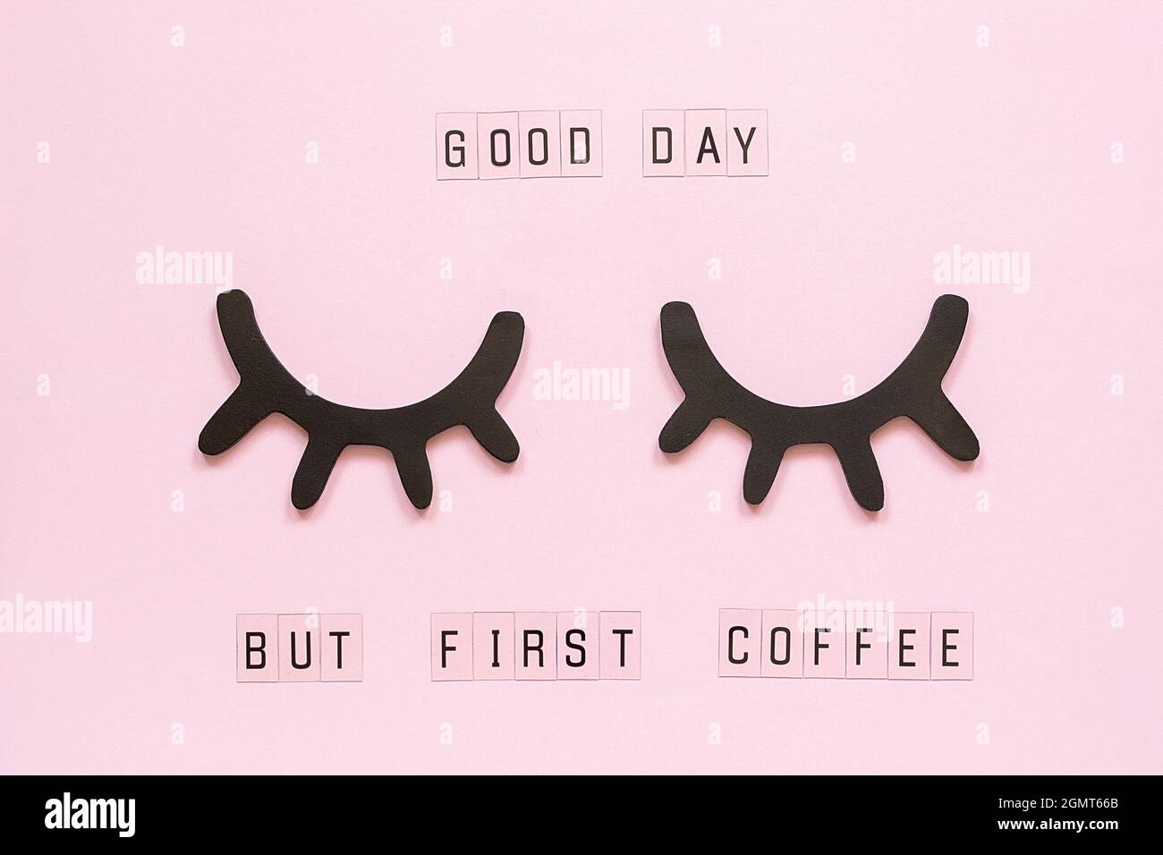 Text Good day, but first coffee and decorative wooden black eyelashes, closed eyes, on pastel pink paper background. Layout Top view Flat lay Concept Stock Photo