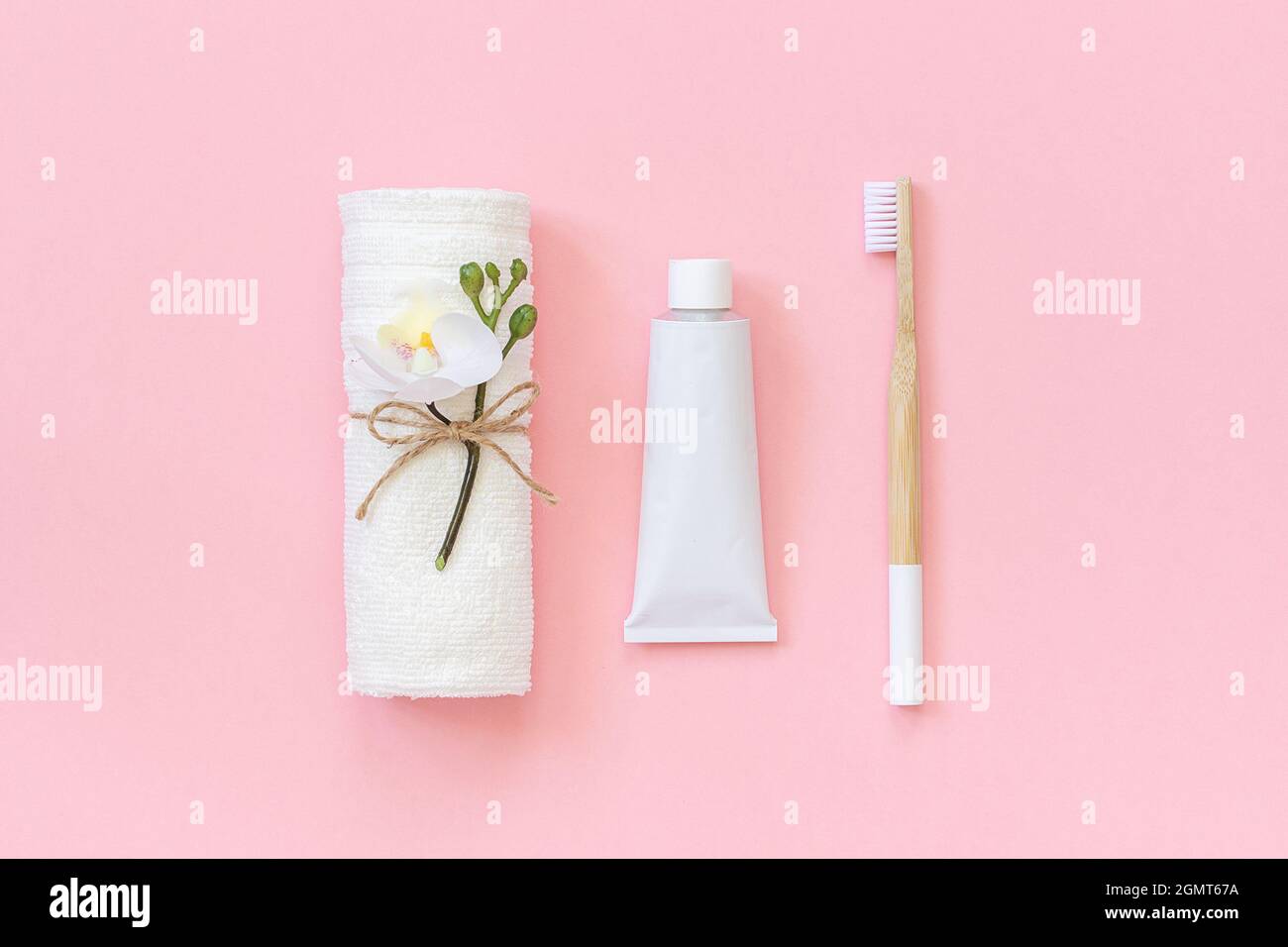 Natural ecofriendly bamboo brush, white towel and tube of toothpaste