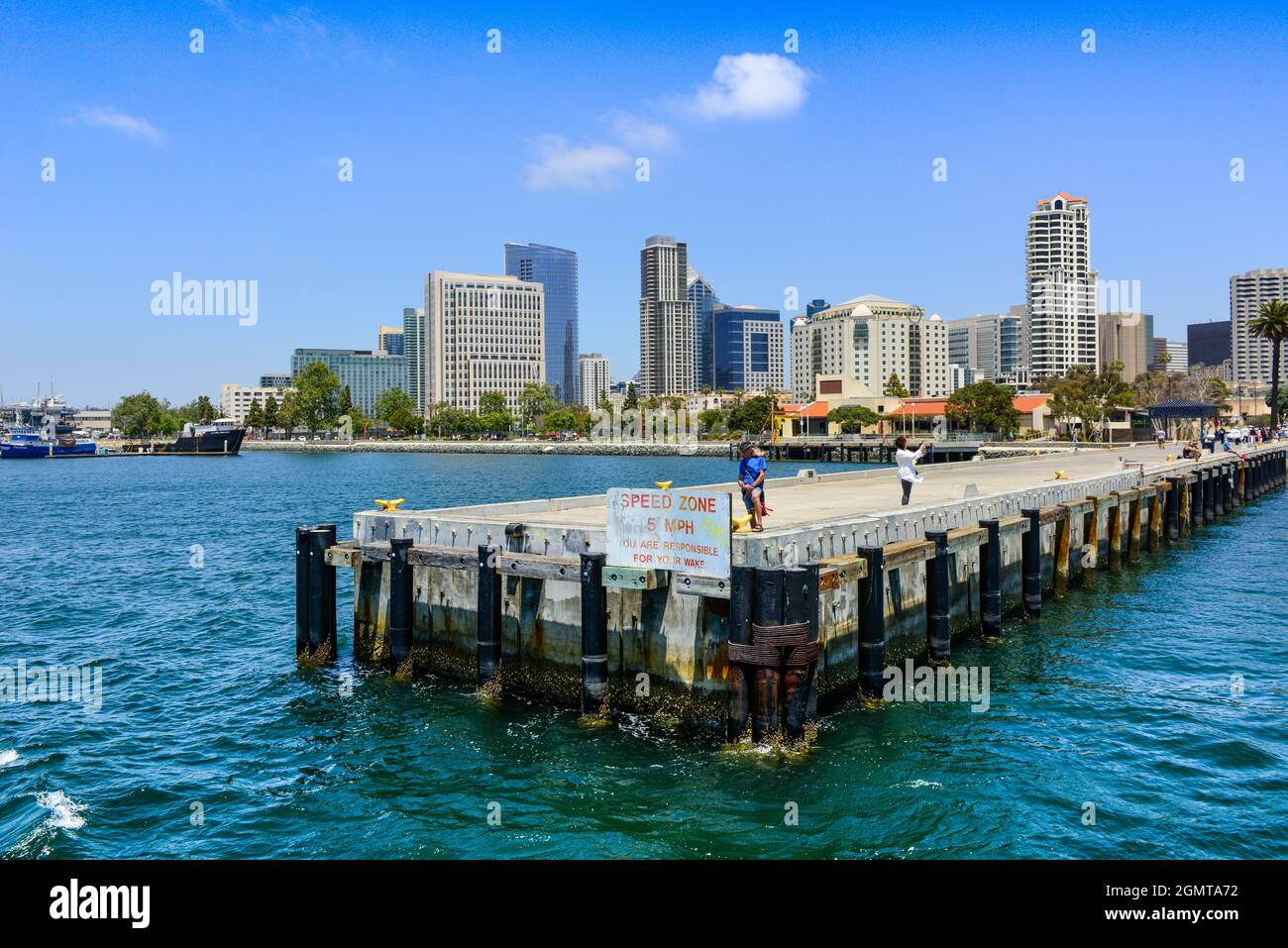 People enjoying the San Diego Bay views from pier and dock areas of the San Diego Harbor with a background of high-rise buildings, San Diego, CA Stock Photo