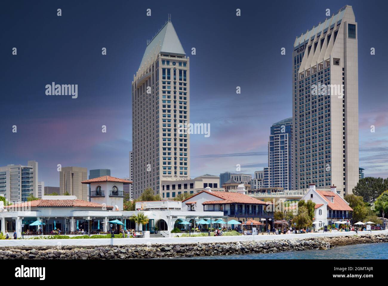 The Edgewater Grill restaurant at Seaport Village, dominated by looming high-rise Manchester Grand Hyatt hotel on the bay in San Diego, CA Stock Photo