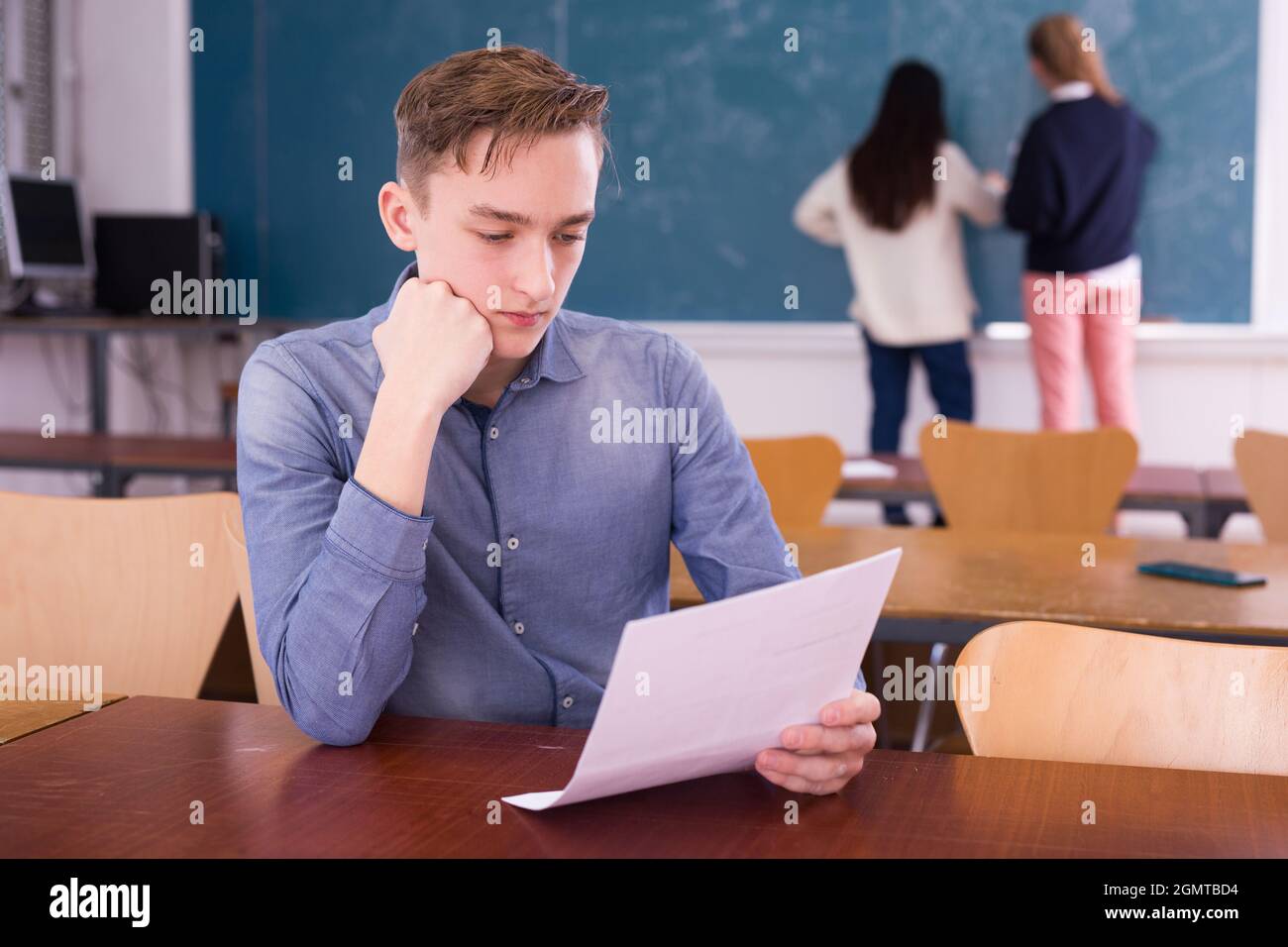 Young thoughtful guy preparing for the exam in classroom Stock Photo