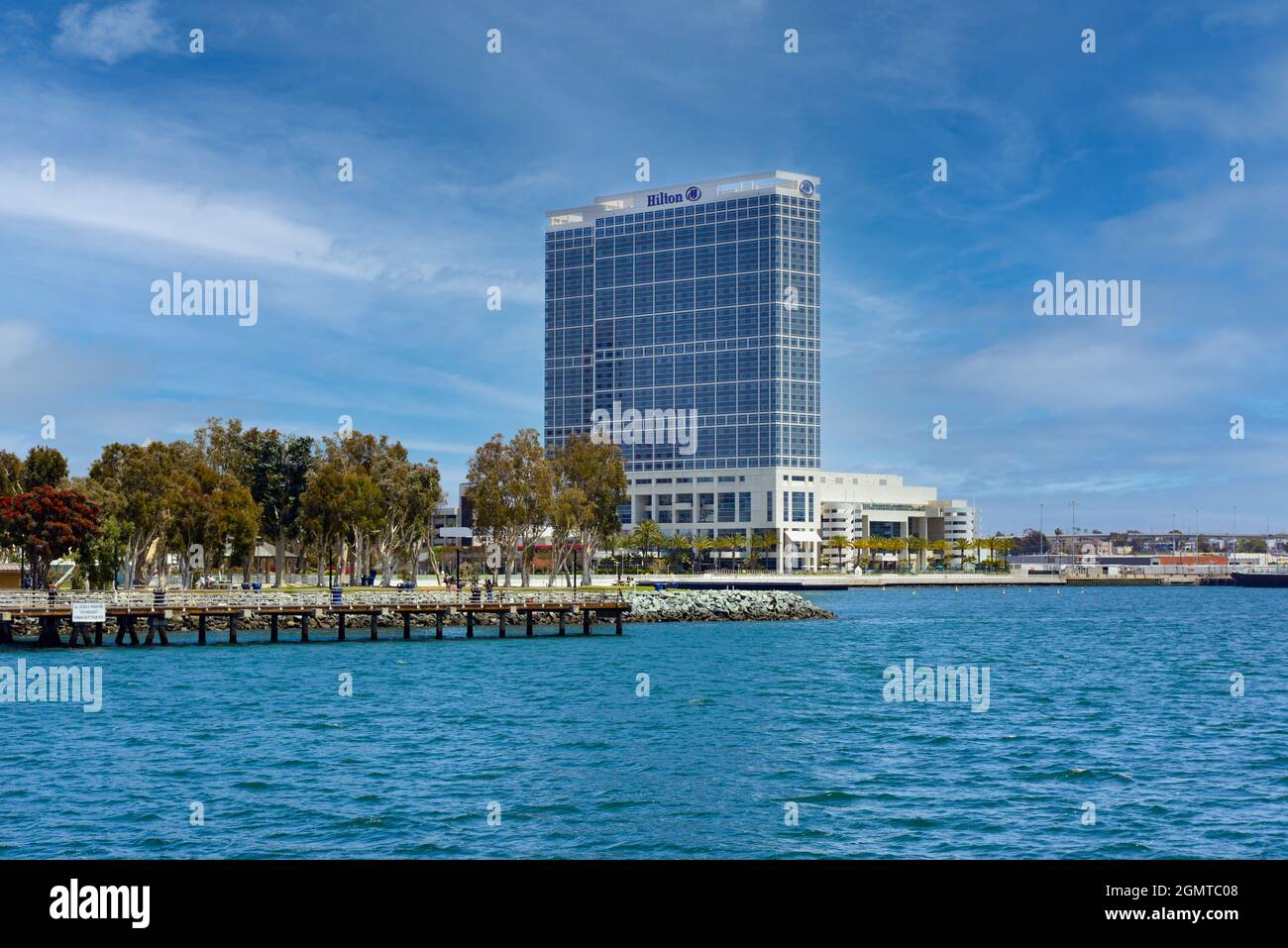 A view across the San Diego Bay of the South Embarcadero Park and the Hilton San Diego Bayfront Hotel across from the Coronado Bridge in San Diego, CA Stock Photo