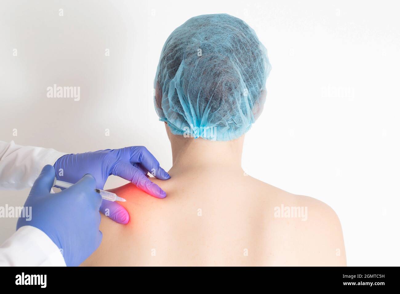 Doctor neurologist injects medical blockade into trigger points to relieve muscle tension and pain in the back and shoulder blades, protrusion Stock Photo