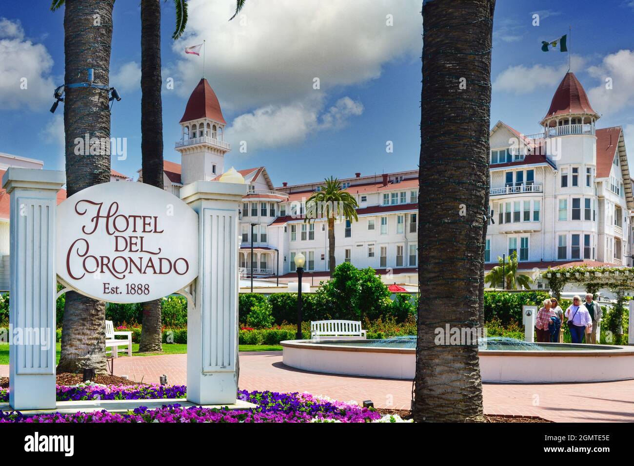 Hotel del Coronado signpost with blooming colorful flowers and palm