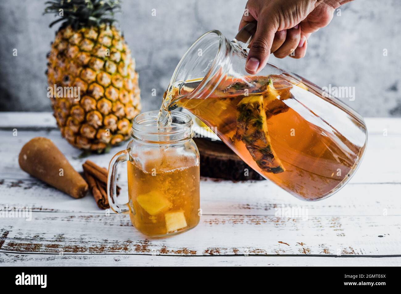 Tepache mexican Fermented pineapple drink and hand holding a Jar with ...