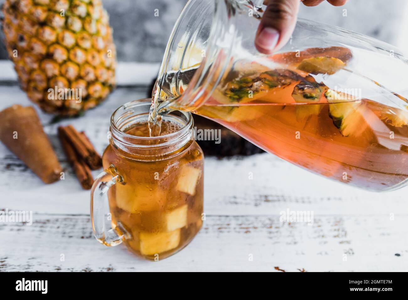 Tepache mexican Fermented pineapple drink and hand holding a Jar with ...