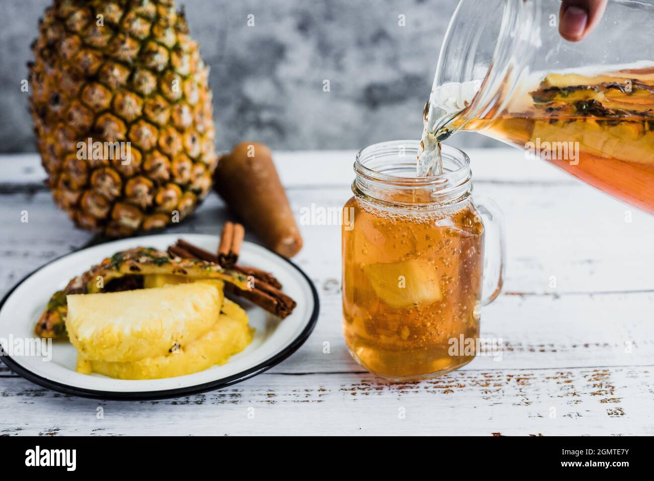 Tepache mexican Fermented pineapple drink and hand holding a Jar with ...