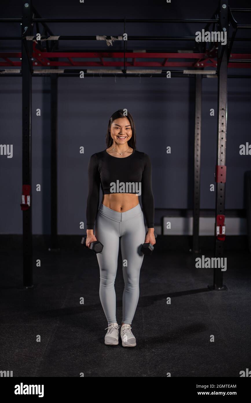 Asian woman doing exercises with dumbbells in the gym Stock Photo - Alamy