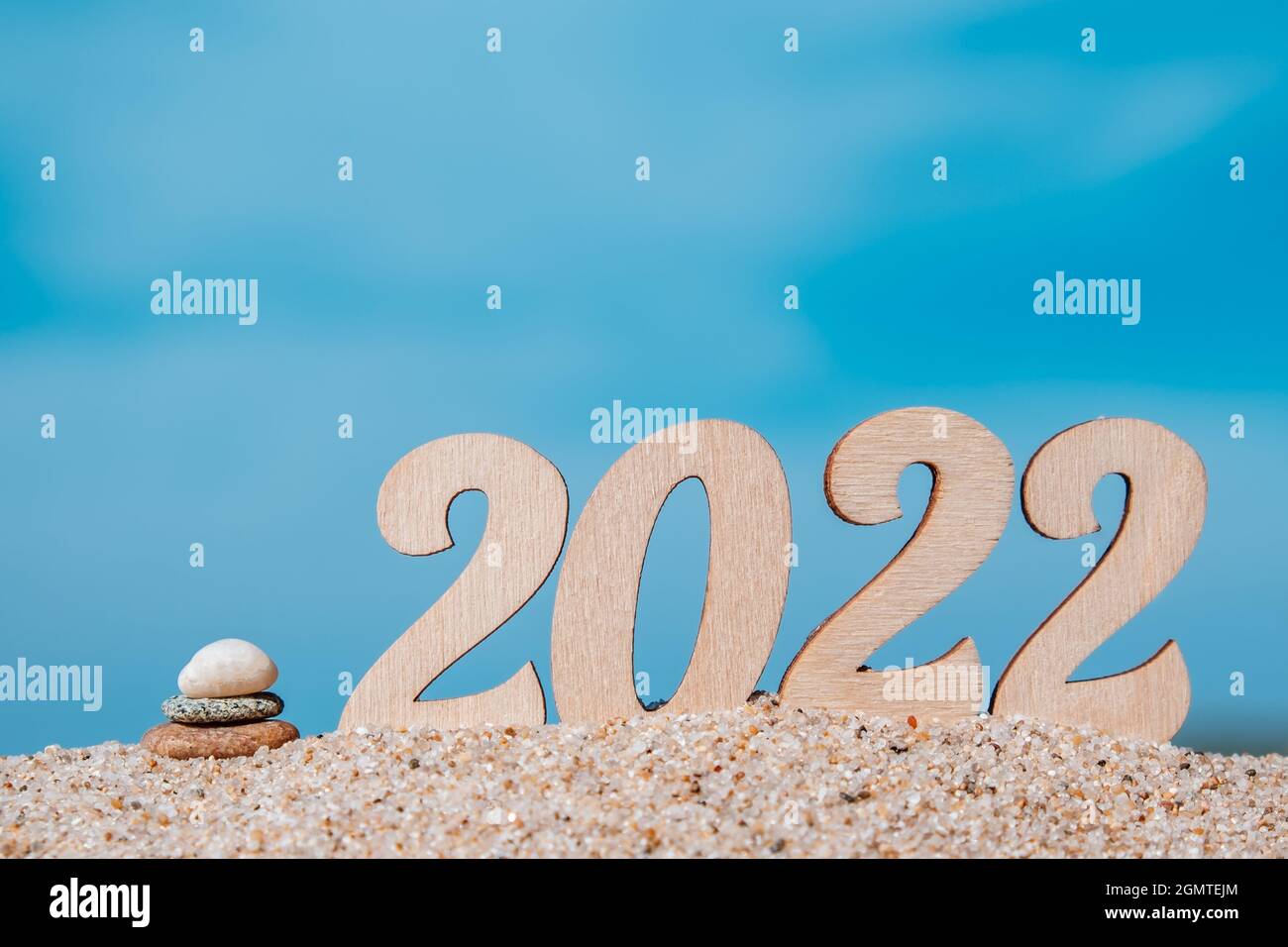 New year numbers 2022 on the beach by the sea, cairn.The concept of tourism, recreation and travel.Creative Christmas card.Selective focus.Copy space. Stock Photo