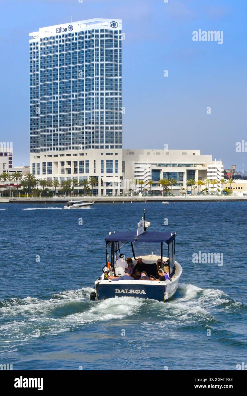 Rear view of water taxi loaded with passengers speeding across the San Diego Bay toward the Hilton San Diego Bayfront Hotel in San Diego, CA Stock Photo