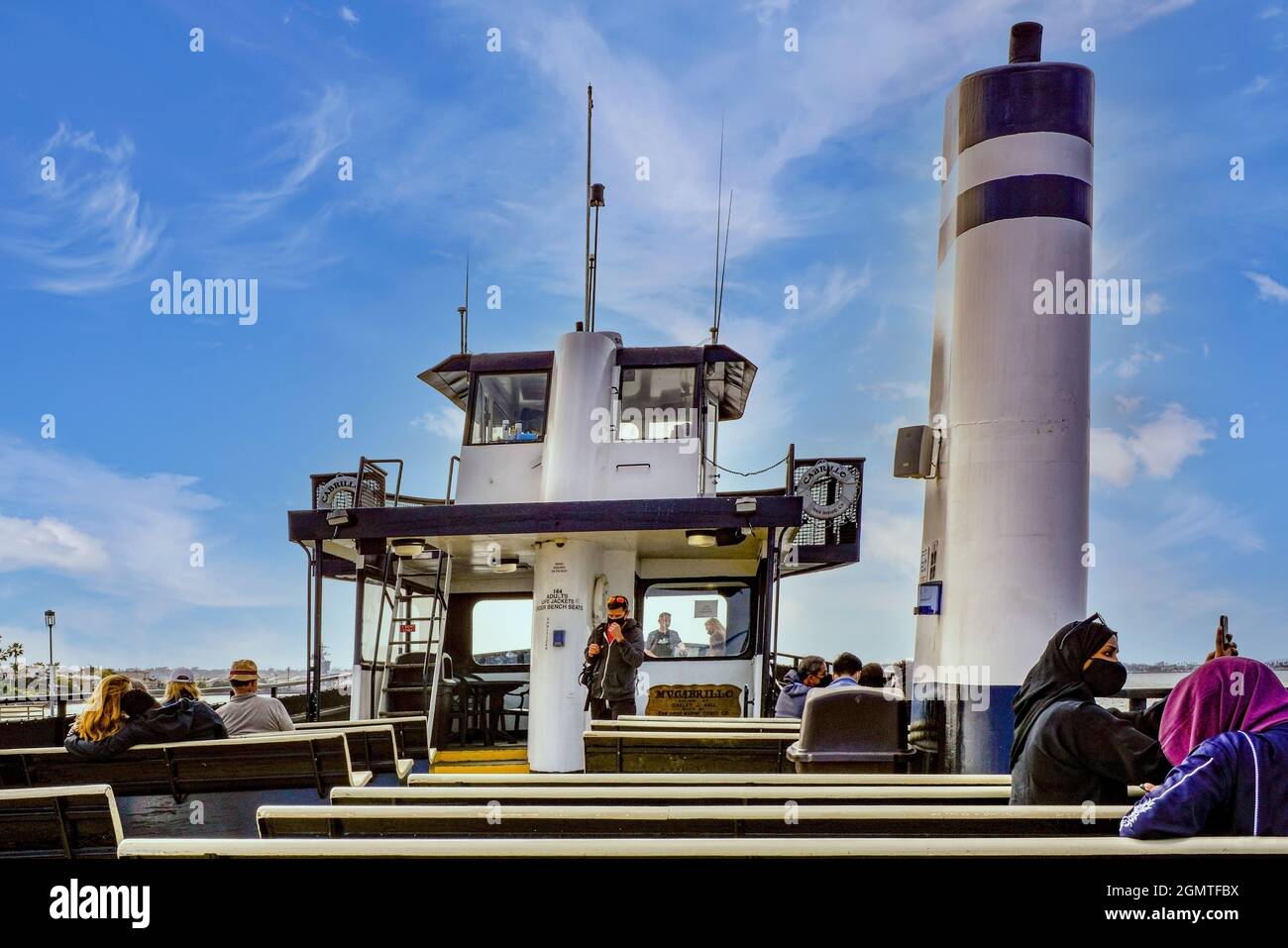 Oversized funnel for exhaust gases dominates the deck with passengers on the Cabrillo Ferry boat crossing the San Diego Bay from Coronado Island, CA Stock Photo