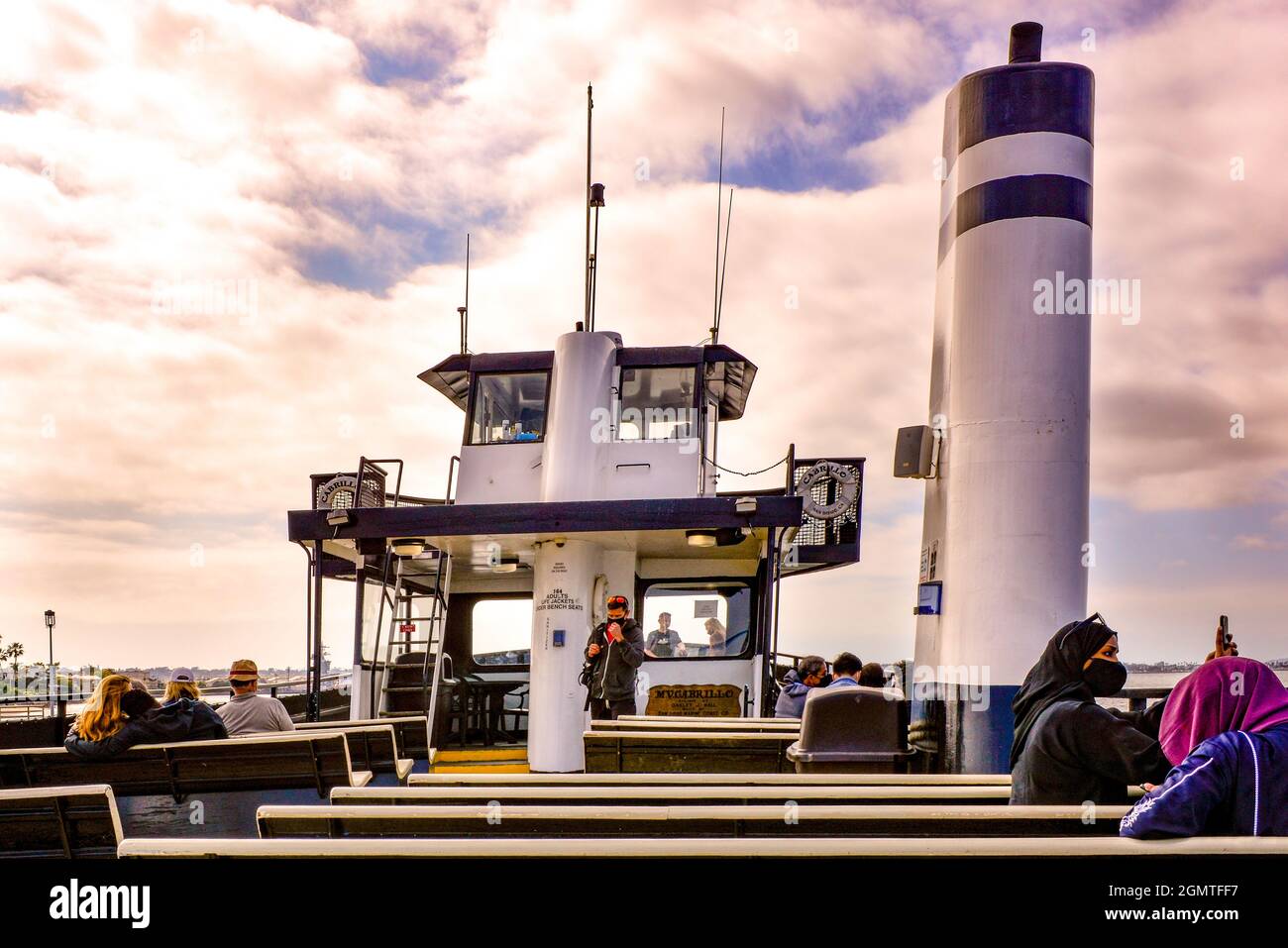 Oversized funnel for exhaust gases dominates the deck with passengers on the Cabrillo Ferry boat crossing the San Diego Bay from Coronado Island, CA Stock Photo