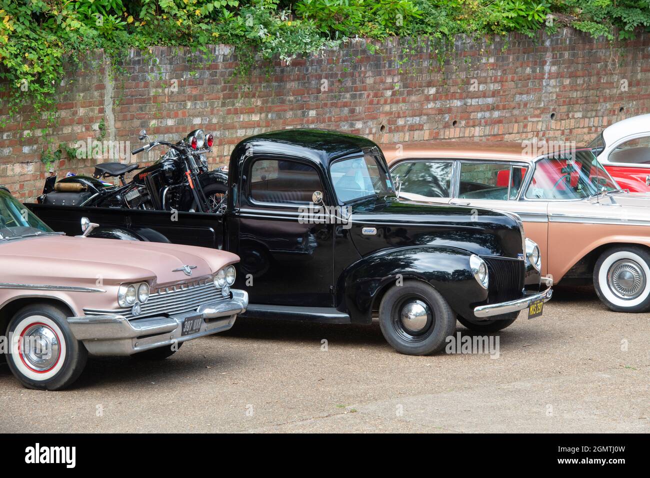 1940 Ford Pick Up with a vintage Harley Davidson motorcycle in the back at Brooklands american car day. UK Stock Photo