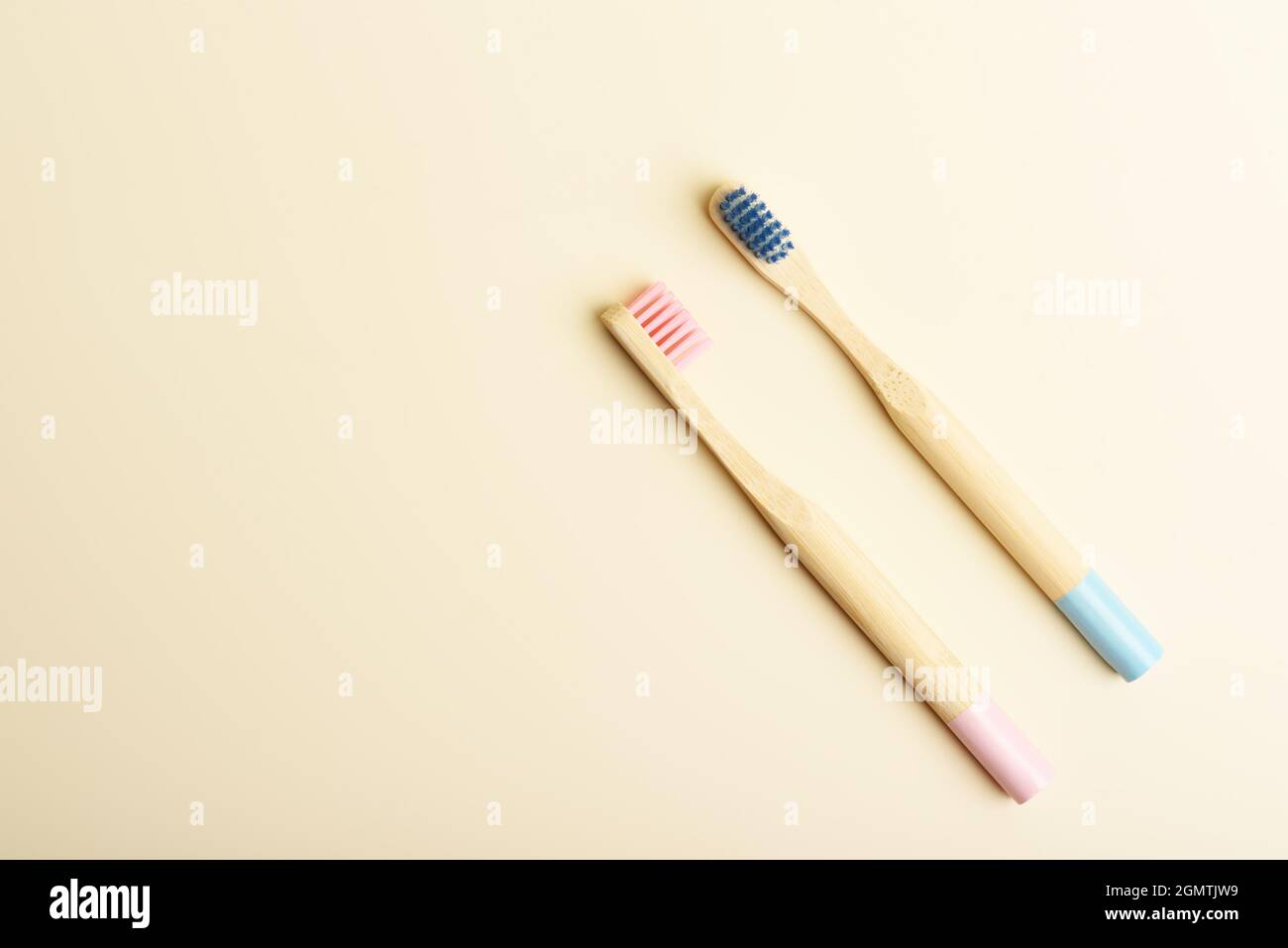 Two eco friendly pink and blue natural bamboo toothbrushes on beige ...