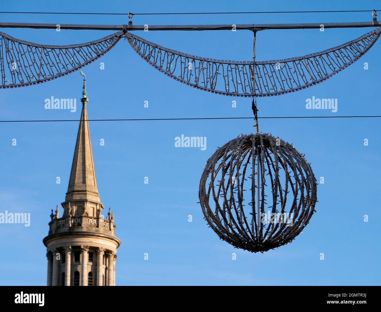 Christmas decorations in Oxford High Street, with one of the city's famous dreaming spires in the background Stock Photo