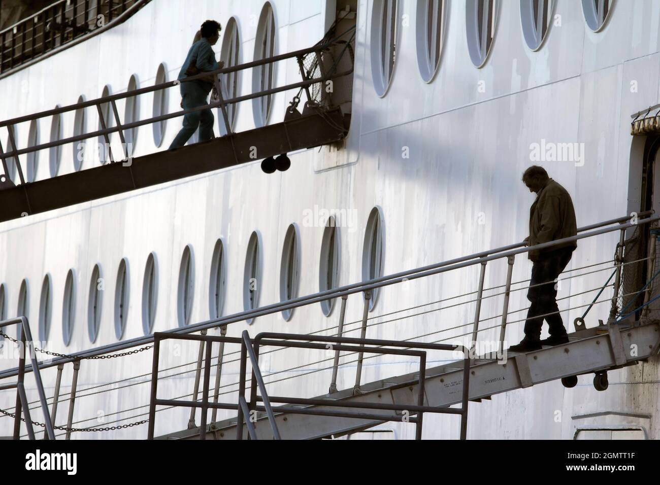 Ketchikan, Alaska USA - 26 May 2010; silhouetted people in view. Here we see passengers embarking and disembarking whilst a cruise liner is moored in Stock Photo