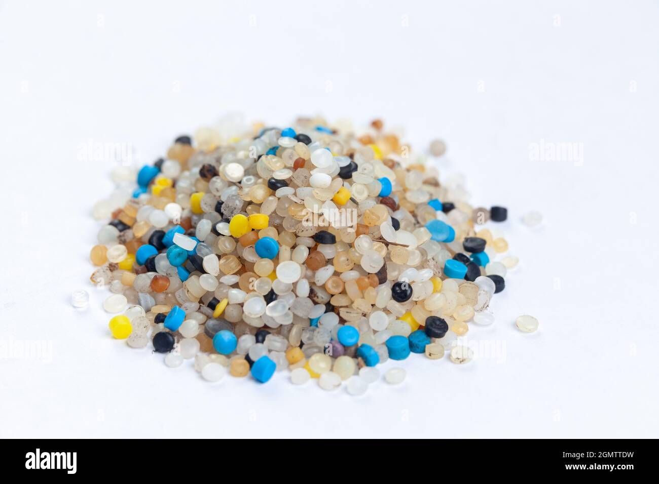 A pile of nurdles collected from the beach on a white background Stock Photo