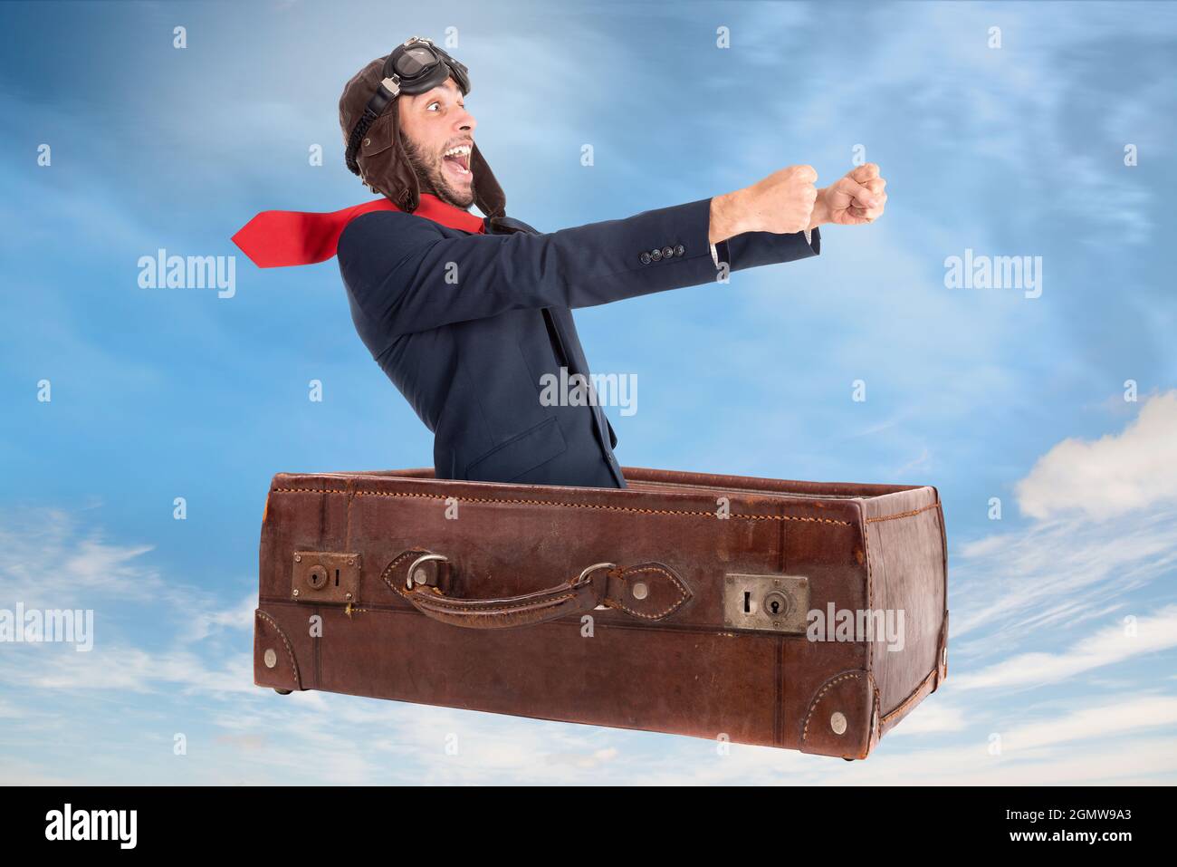 Businessman flying an old suitcase over the skies Stock Photo