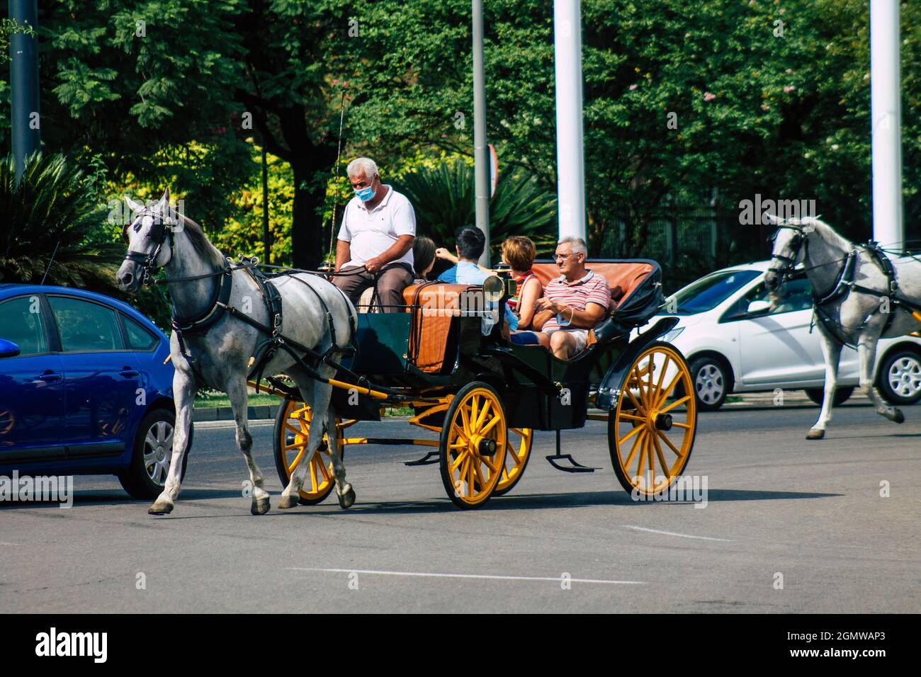 Seville Spain September 15, 2021 Horse drawn carriage ride through the streets of Seville during the coronavirus outbreak hitting Spain, wearing a mas Stock Photo