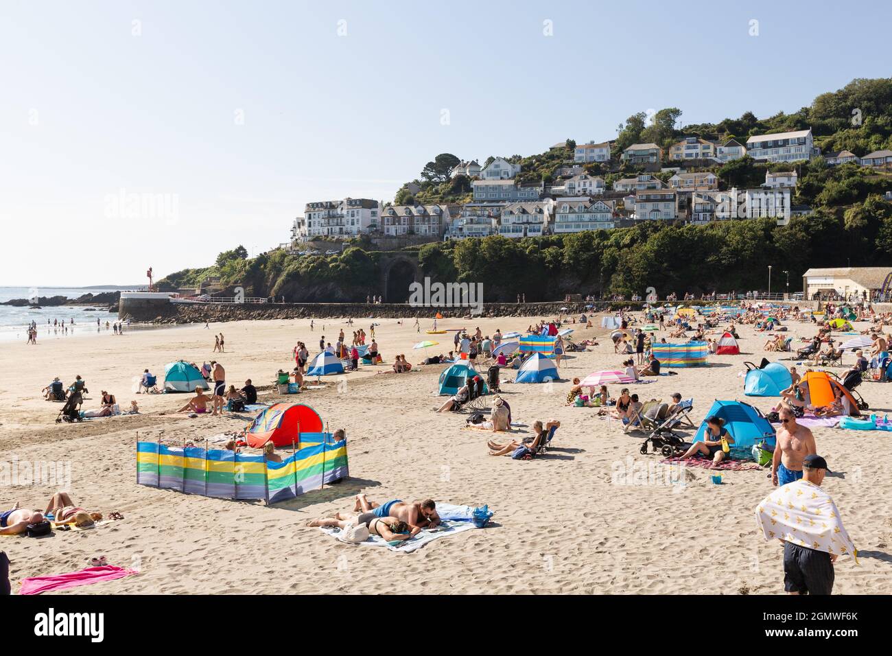 People sunbathing on beach at Looe, Cornwall, viewed from the promenade. Stock Photo