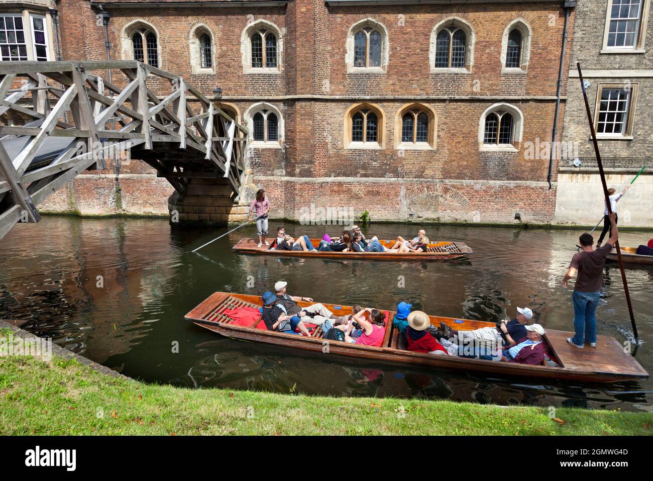 Cambridge, Cambridgeshire - 20 July 2009; Group of people in view, having fun. Punting on the River Cam in summer, approaching Mathematical Bridge of Stock Photo