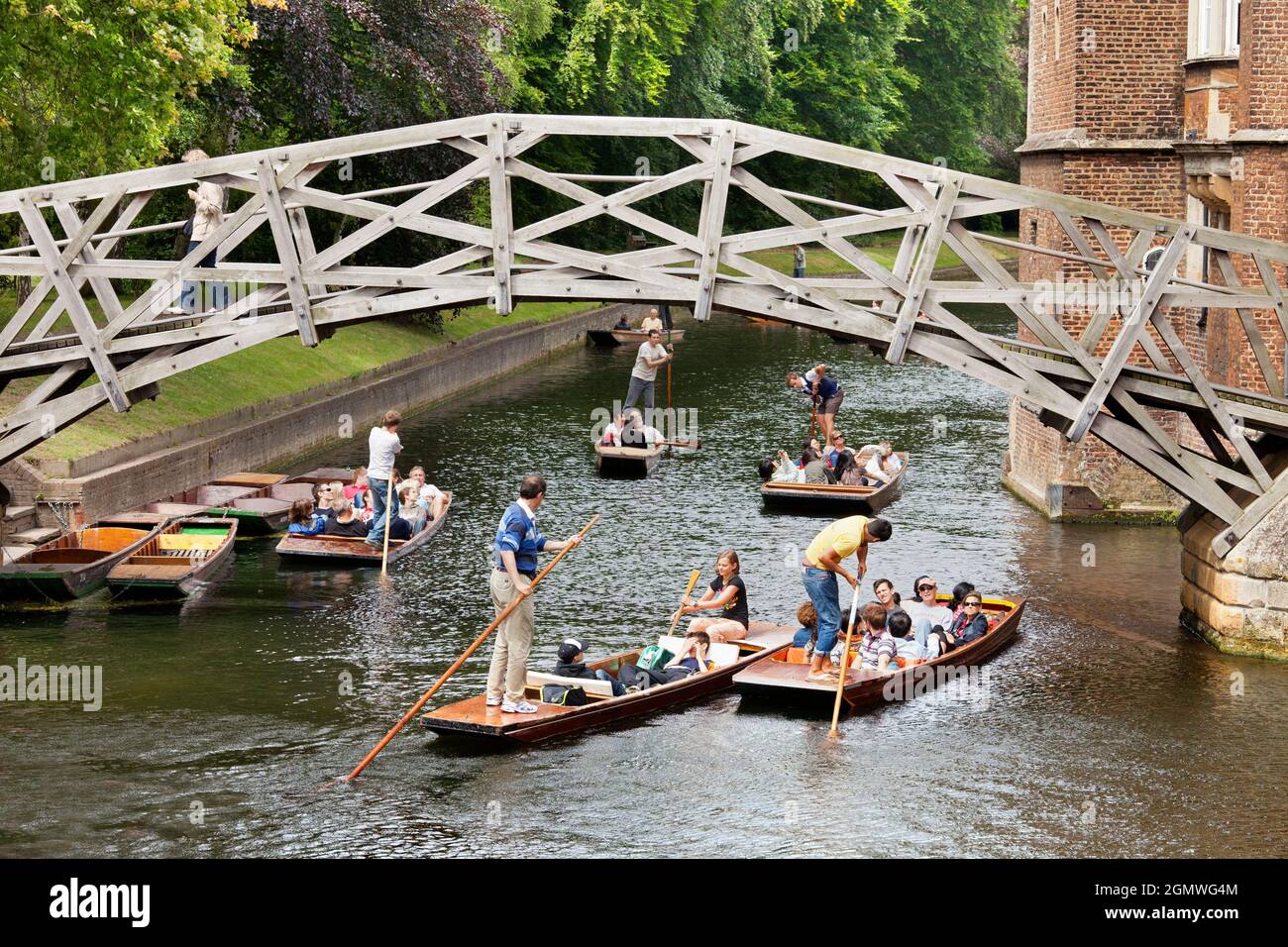 Cambridge, Cambridgeshire - 20 July 2009; Group of people in view, having fun. Punting on the River Cam in summer, approaching Mathematical Bridge of Stock Photo