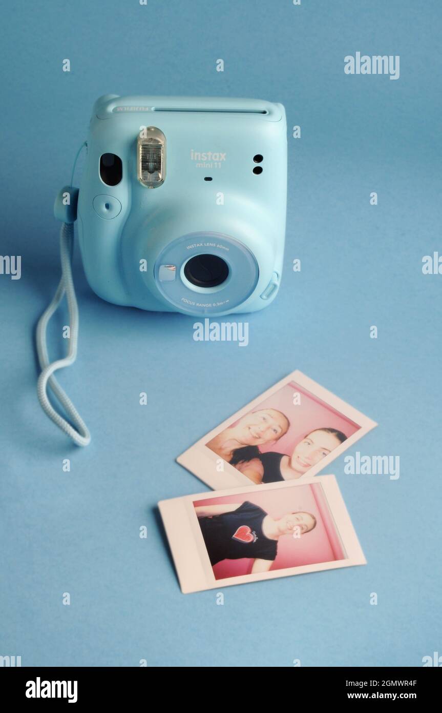 Retro camera. Instant Polaroid blue camera: FUJIFILM INSTAX Mini 11 Instant  Film Camera and printed images Stock Photo - Alamy