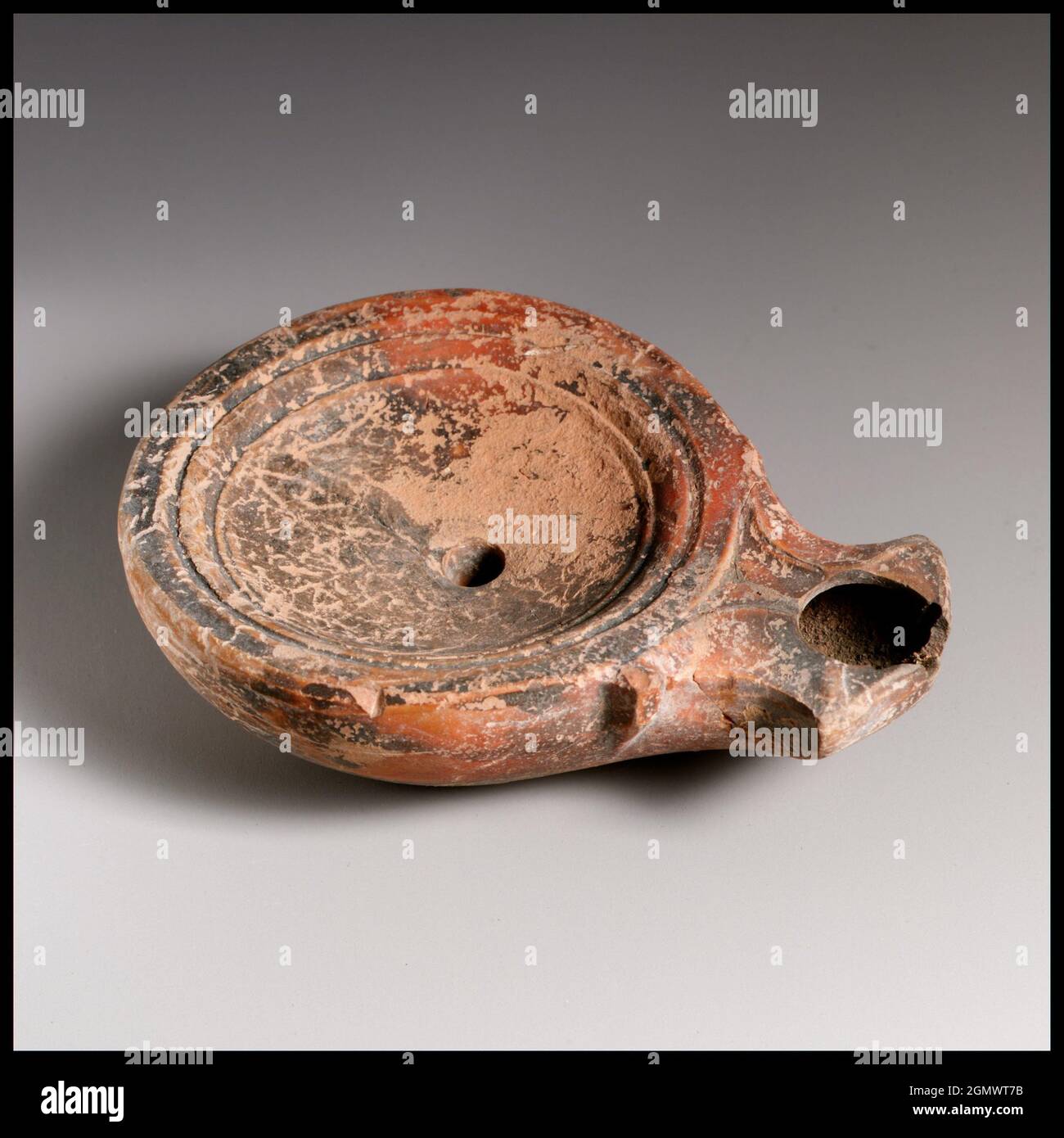 Lamp. Culture: Roman, Cypriot; Medium: Terracotta; Dimensions: Overall: 1 x 3 1/2 in. (2.5 x 8.9 cm); Classification: Terracottas Stock Photo
