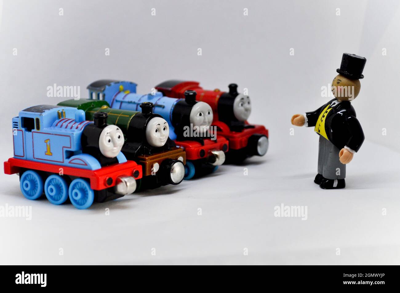 The Fat Controller speaking with toy die cast engines set against a white background Stock Photo