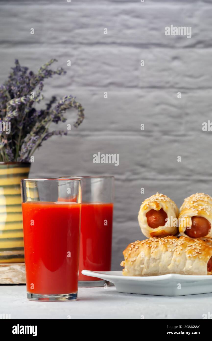 Tomato juice with sausage in a dough on a platter Stock Photo Alamy