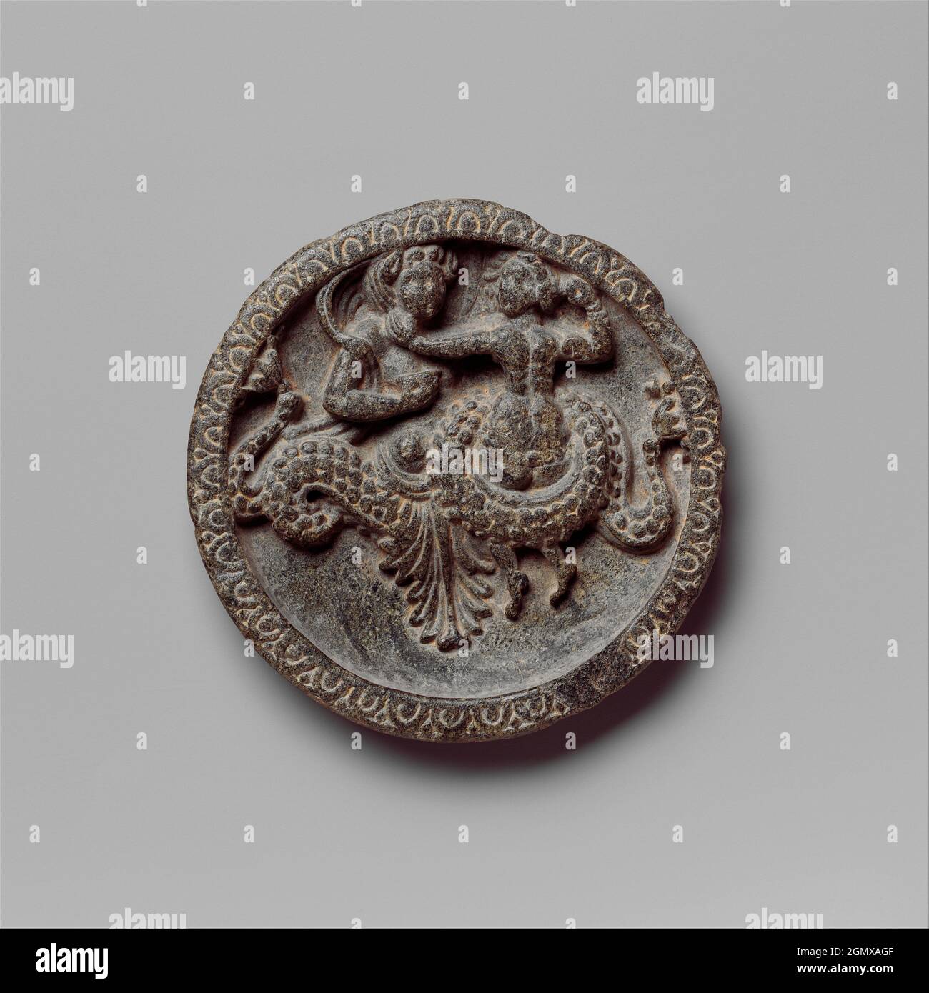 Dish with Marine Creature and Couple. Date: 1st century B.C; Culture: Pakistan (ancient region of Gandhara); Medium: Schist; Dimensions: Diam. 4 1/2 Stock Photo