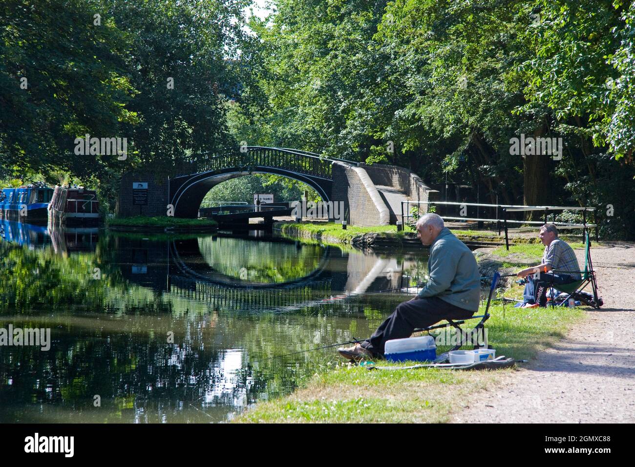 Oxford, England - 2006; Idyllic summer scene of two fishermen by Isis Lock on the Oxford Canal. How quintessentially English can you get? Stock Photo