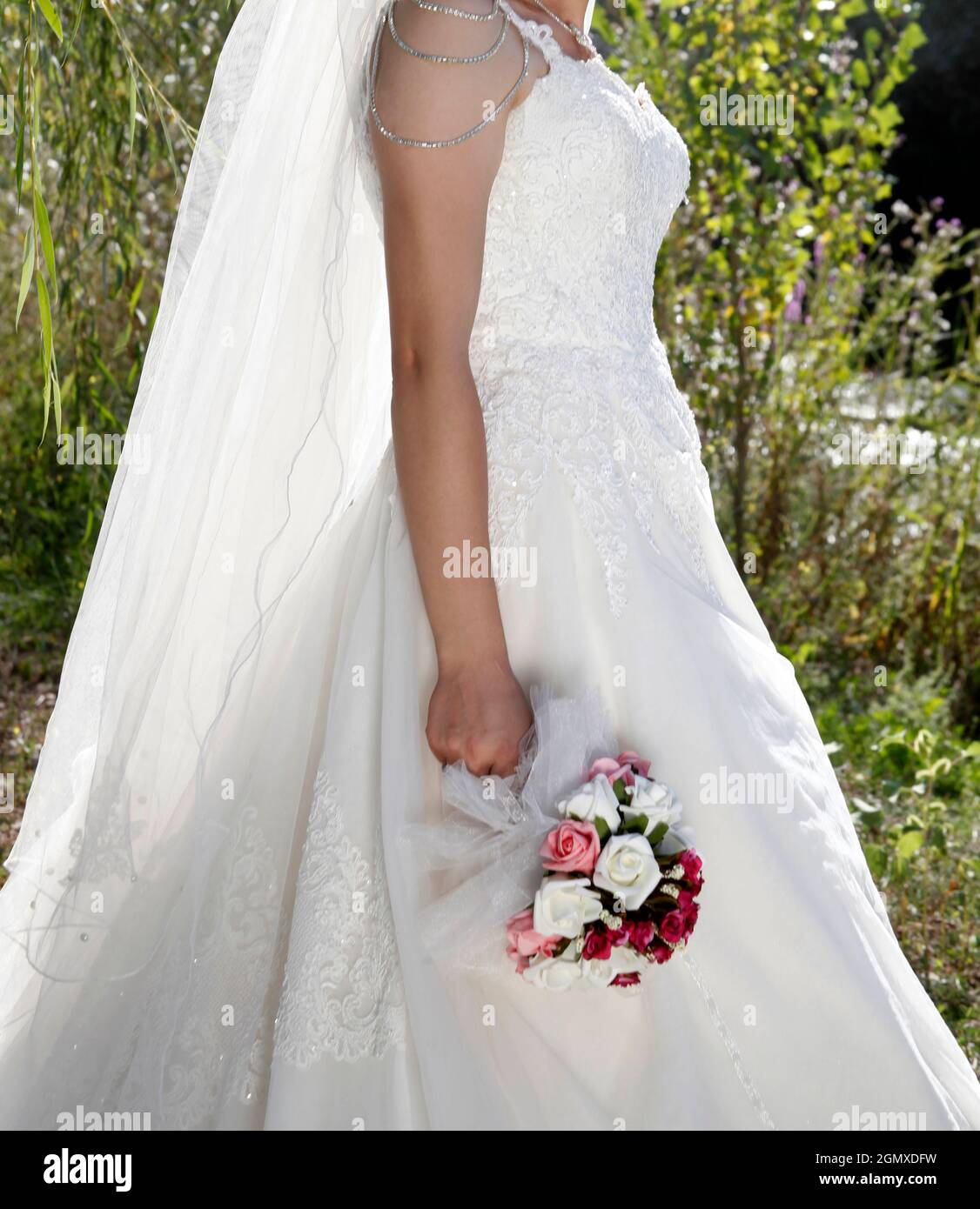 Bride in white wedding dress with lace, embroidery. A bouquet of ...