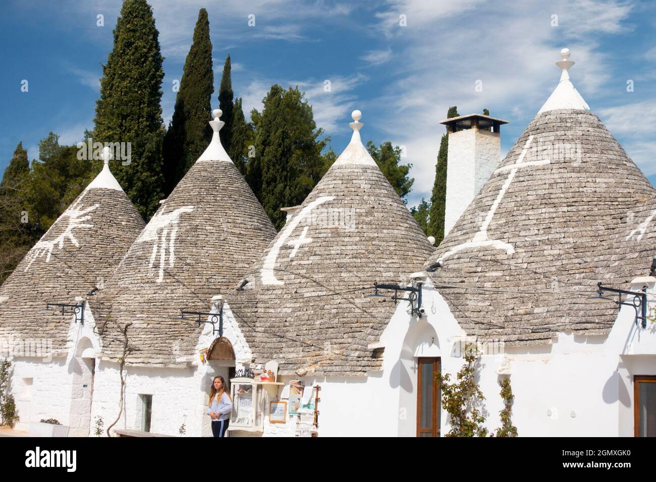 Alberobello, Italy - 10 April 2018; one woman in shot. Albeloberro is a small town close to Bari in Southern Italy. Its main claim to fame are its tin Stock Photo