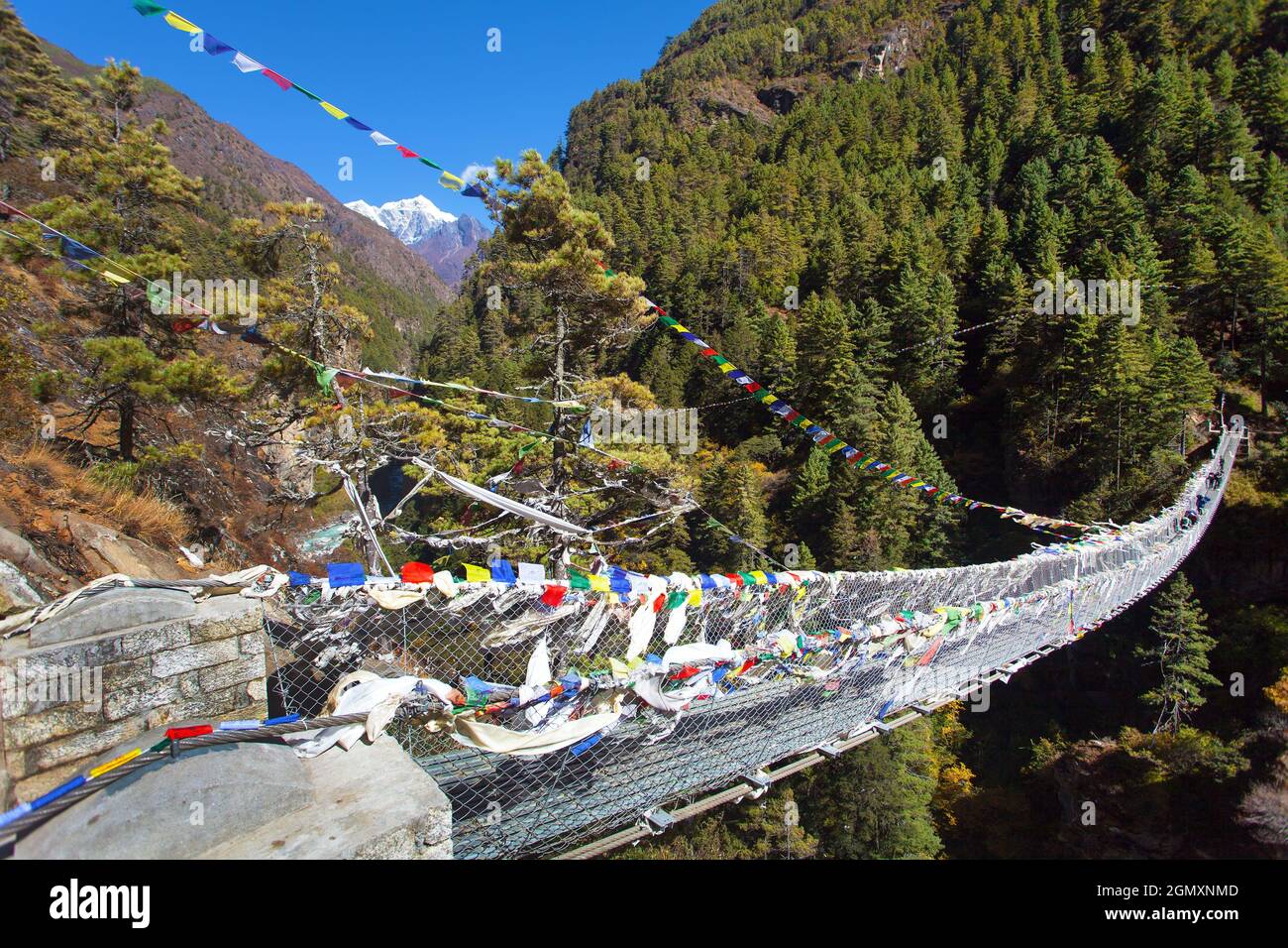 Rope hanging suspension bridge with prayer flags in Nepal Himalayas