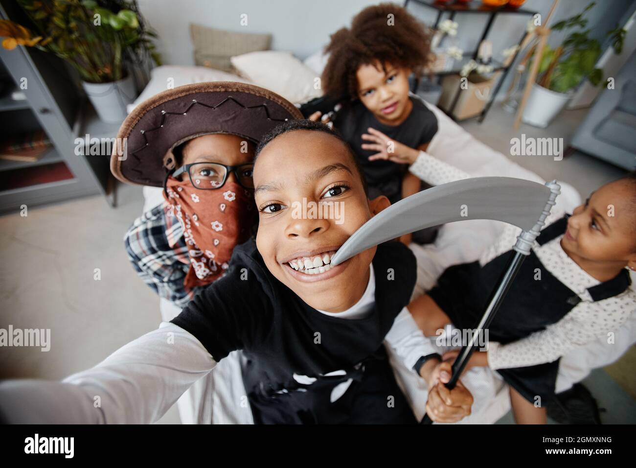 POV shot of smiling African-American kids wearing Halloween costumes while taking selfie at home, copy space Stock Photo