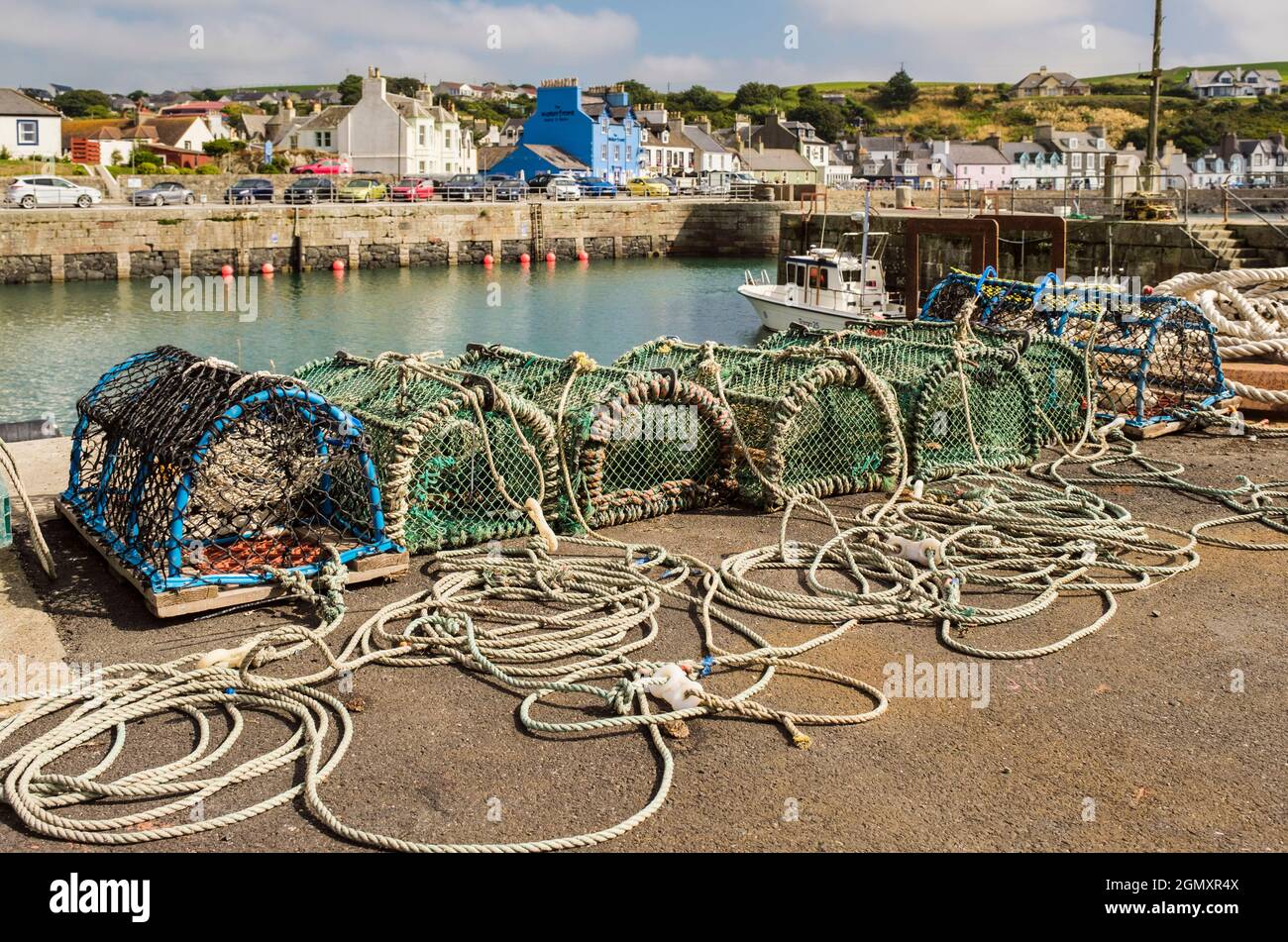 Lobster creels on quay of harbour in small picturesque west coast fishing village.  Portpatrick, Dumfries and Galloway, Scotland, UK, Britain Stock Photo