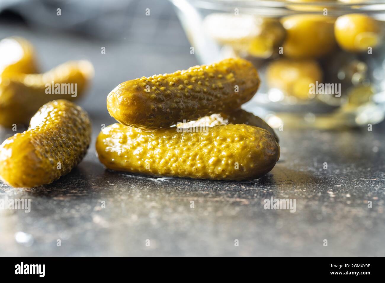 Small pickles. Marinated pickled cucumbers on kitchen table. Stock Photo