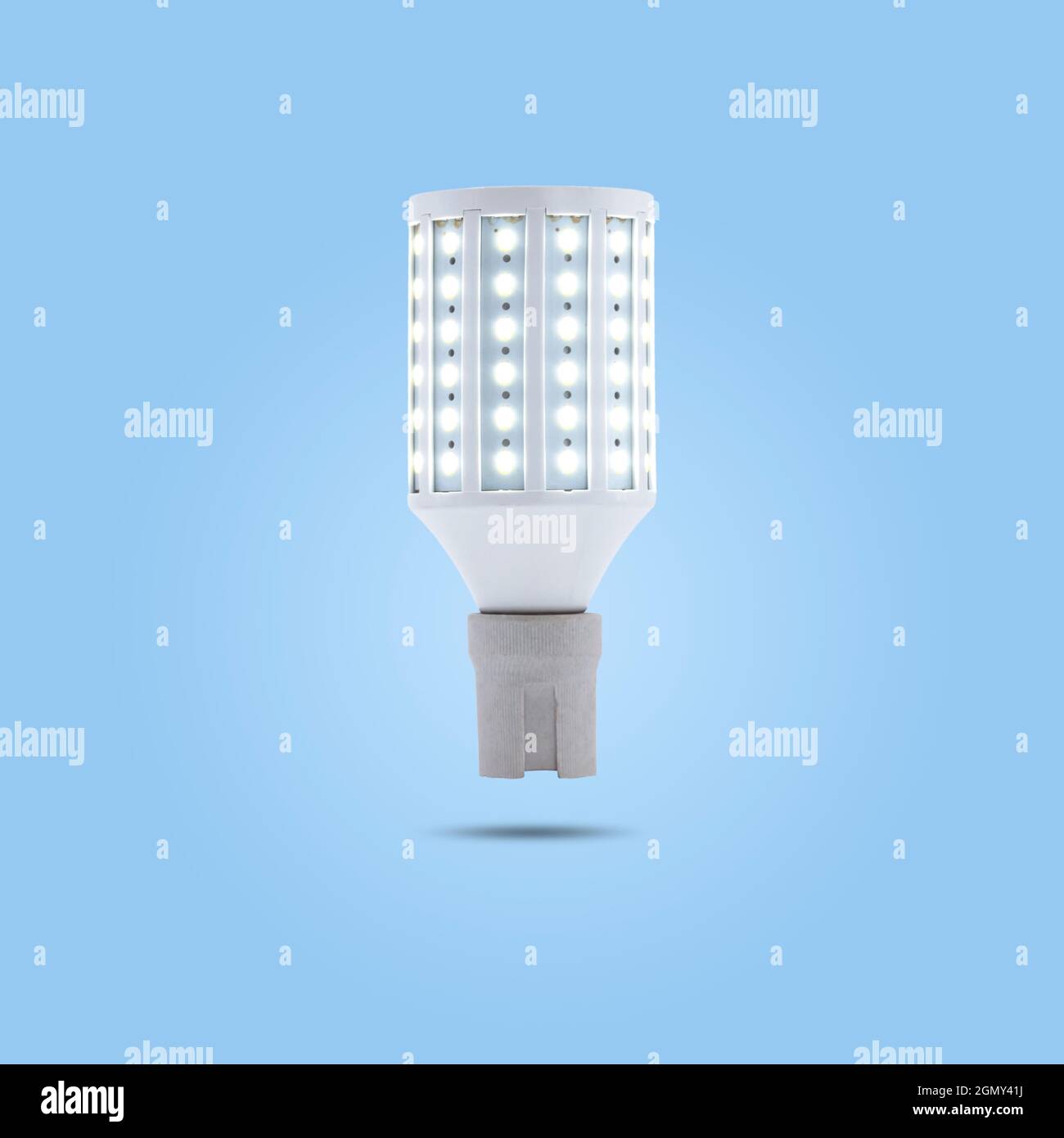 LED energy saving lamp 230v in a ceramic socket isolated on blue pastel color background. Stock Photo