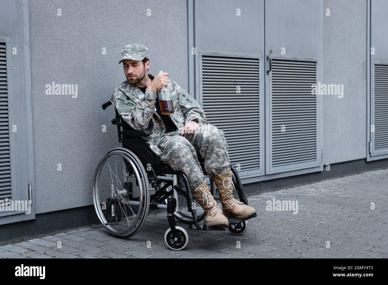 handicapped veteran sitting in wheelchair with bottle of alcohol on city  street Stock Photo - Alamy