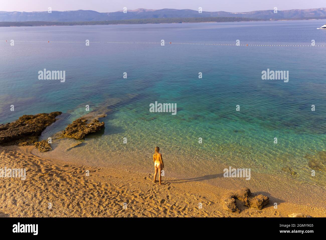 A nudist girl on a sandy beach in Croatia Stock Photo - Alamy