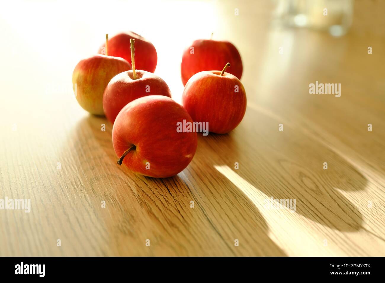 Autumn red apples on a wooden table in the sun. autumn background Stock Photo