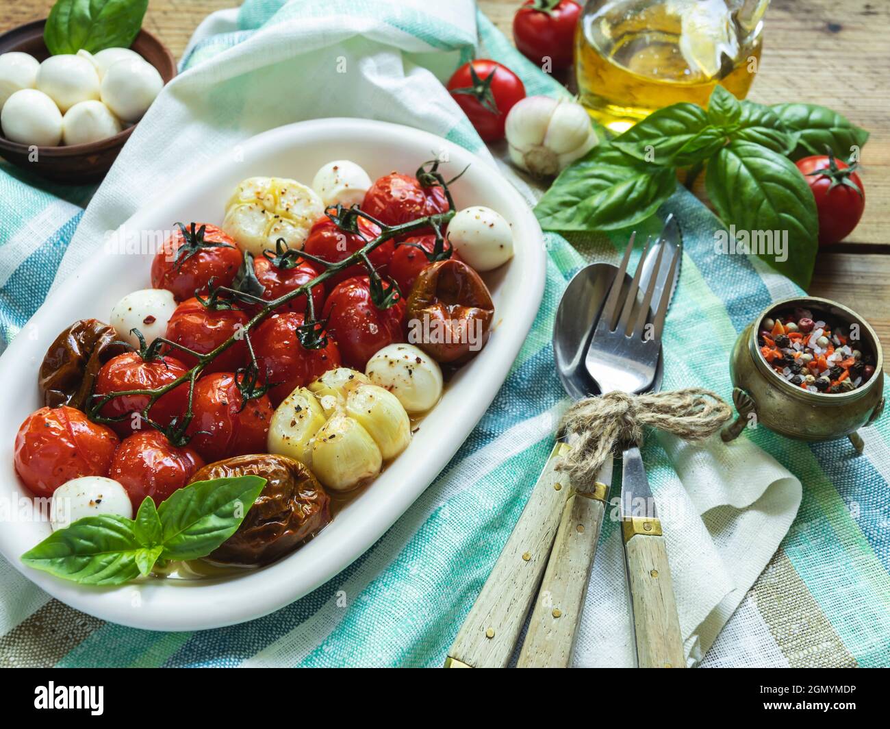 Salad. Baked tomato, basil, garlic with mozzarella cheese, ceramic dishes. cooking, cooked dish. Stock Photo