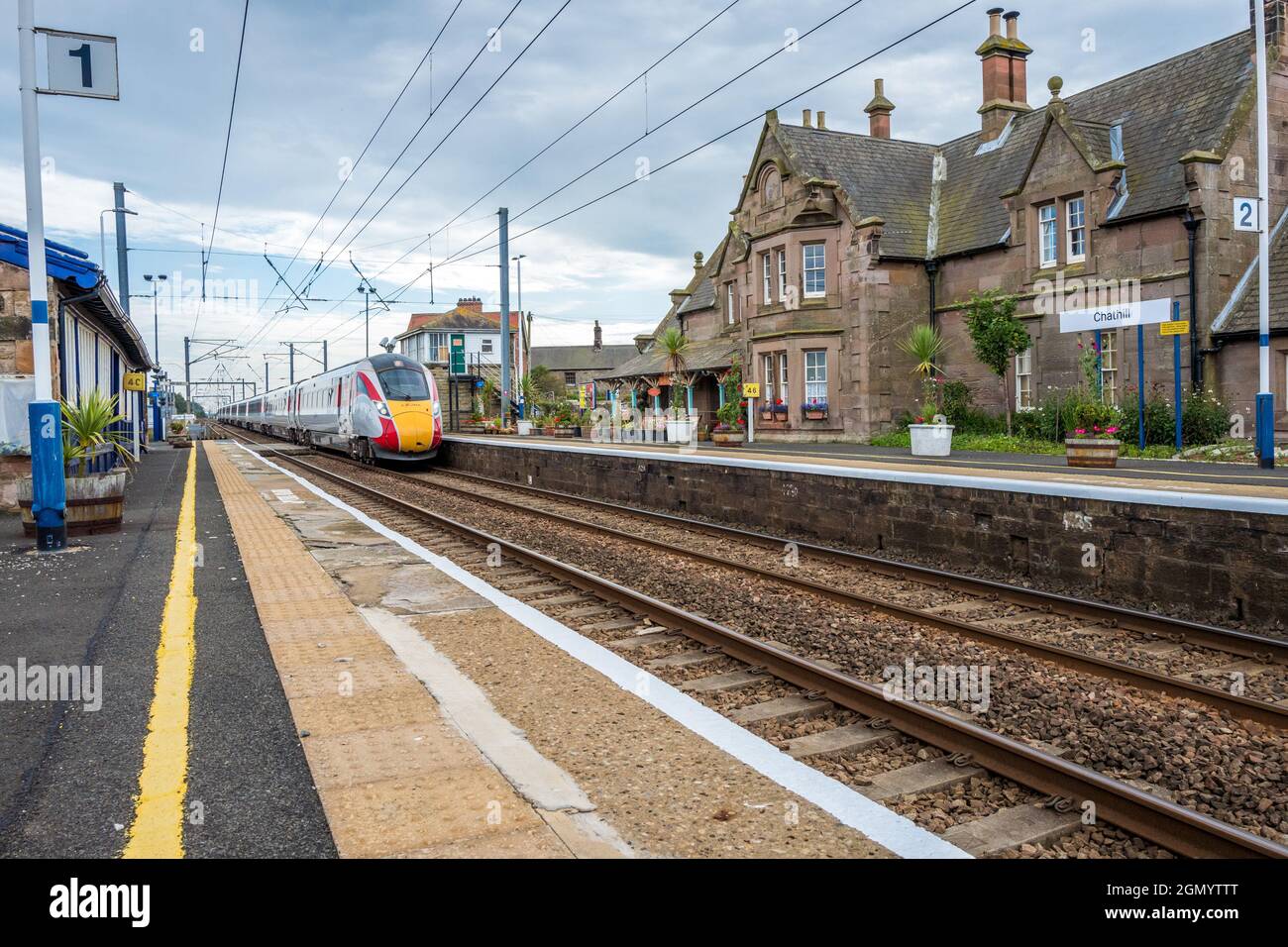Azuma electrified train passing through the Grade 2 listed Chathill railway station on the east coast mainline. Stock Photo