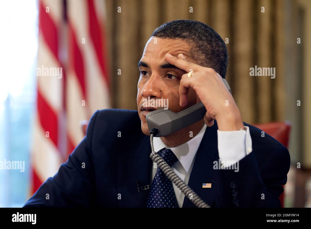 President Barack Obama makes a call from the Oval Office, May 29, 2009.   (Official White House Photo by Pete Souza) This official White House photograph is being made available for publication by news organizations and/or for personal use printing by the subject(s) of the photograph. The photograph may not be manipulated in any way or used in materials, advertisements, products, or promotions that in any way suggest approval or endorsement of the President, the First Family, or the White House. Stock Photo