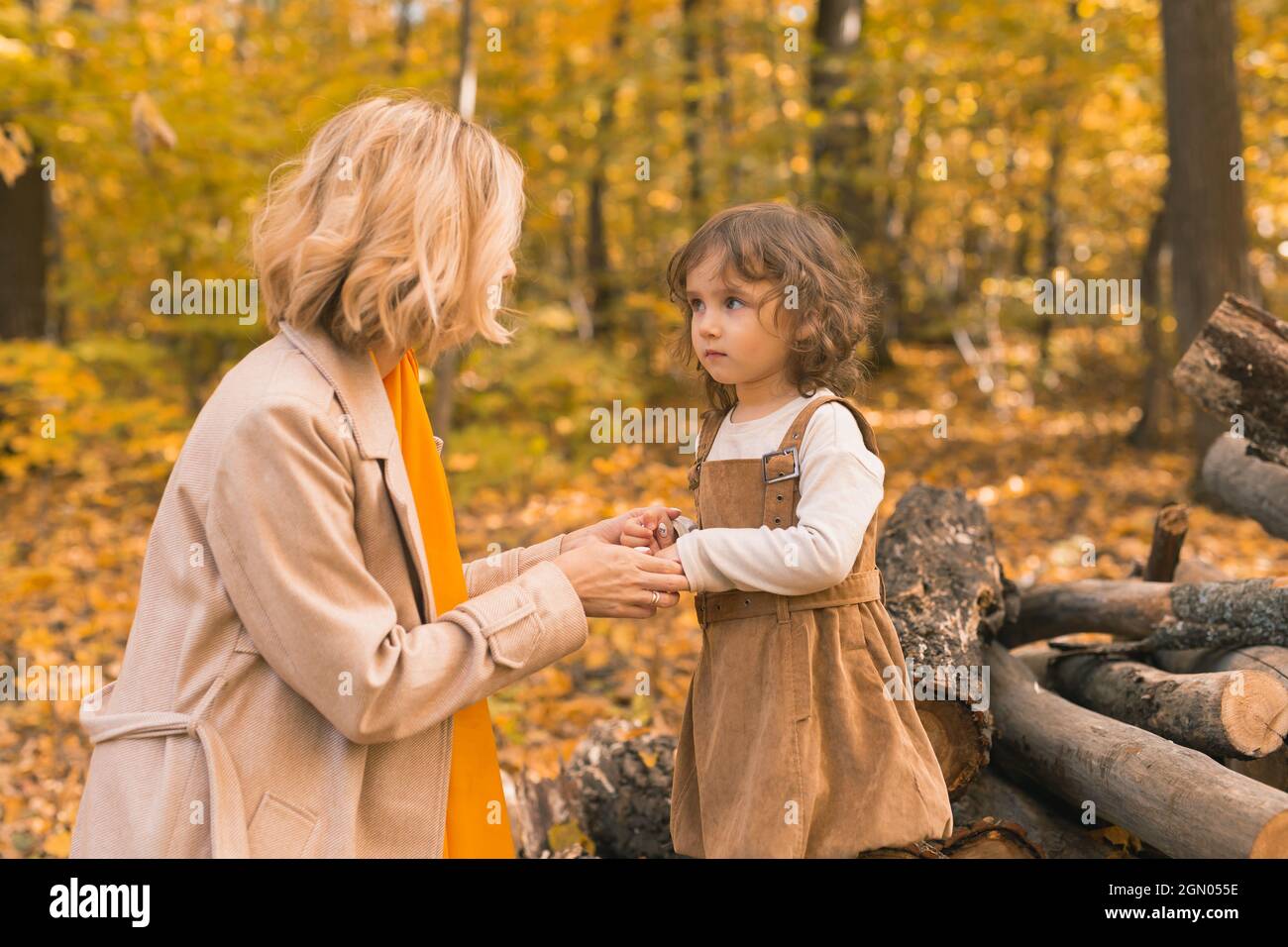 Young mother with her little daughter in an autumn park. Fall season ...