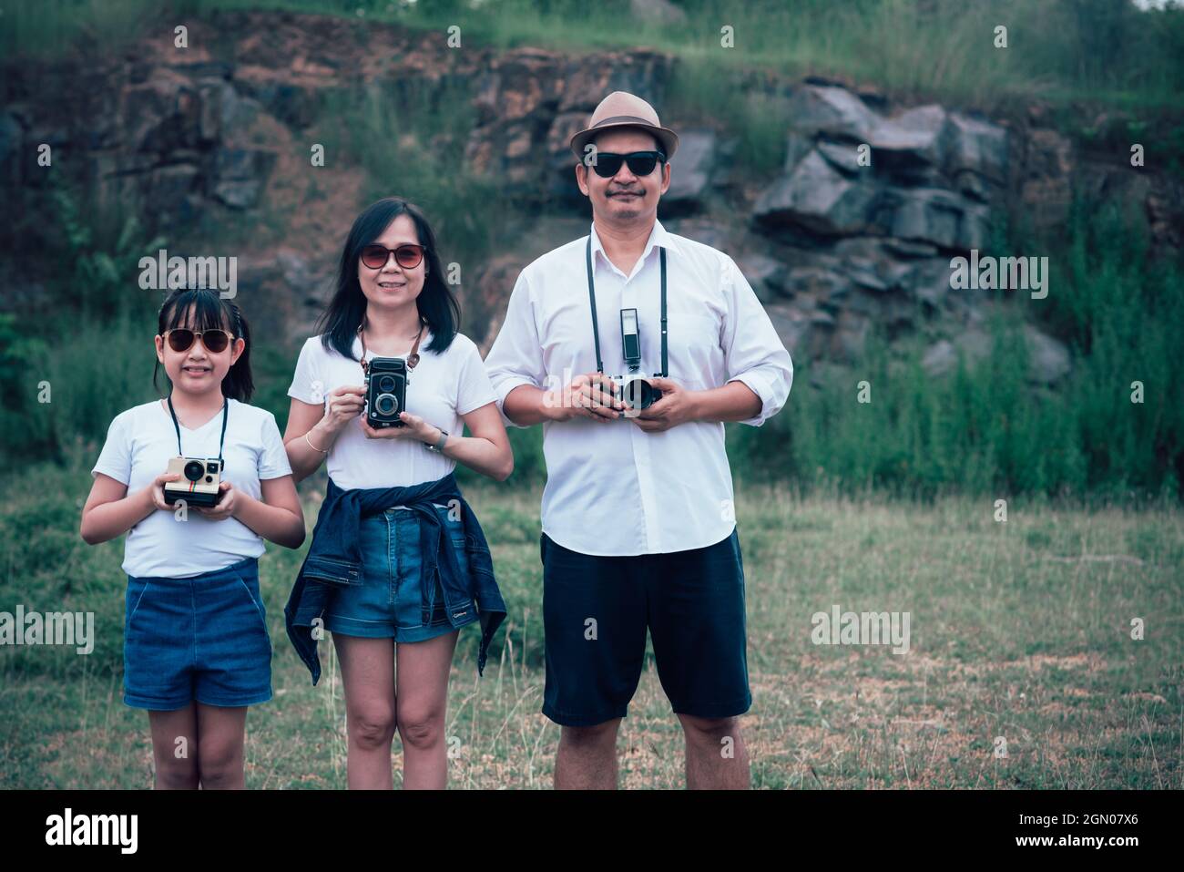Family Using Filming Camera Vintage family of photographers are happily taking pictures with the ...